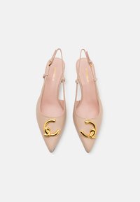 Koonusekujulised, beezist nahast slingback-kapped, millel on kuldne metalline aksessuaar. Seal on slingback-riba ja sile tekstuur. Sobivad ametlikuks kandmiseks.