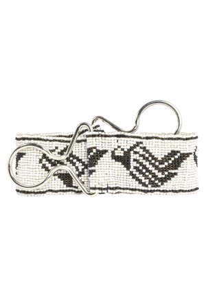 Bracelet en perles noir et blanc avec motifs géométriques et fermoir à boucle en métal argenté sur fond blanc.