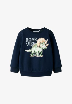 Sweat-shirt bleu marine avec un motif de dinosaure représentant un tricératops, texte "ROAR VIBE", poignets côtelés et col rond.