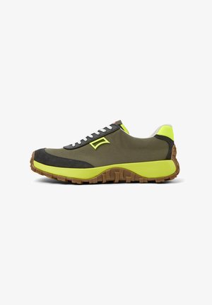 Sneaker with a green canvas upper, black suede accents, bright yellow outsole, white laces, and a textured sole for grip.