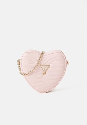 Sac en simili cuir matelassé en forme de cœur, de couleur rose, avec une bandoulière en chaîne dorée et un accent de logo triangulaire. Fermeture éclair sur le dessus.