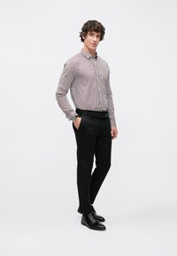 Camisa a rayas de botones en rojo y blanco, cinturón negro, pantalones negros de corte slim, zapatos de vestir negros brillantes; diseño minimalista, textura suave.