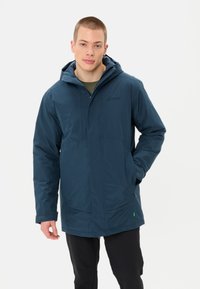 Giacca impermeabile blu navy con cappuccio, dotata di zip frontale, tasche laterali e logo sul petto. Realizzata in tessuto liscio e resistente.