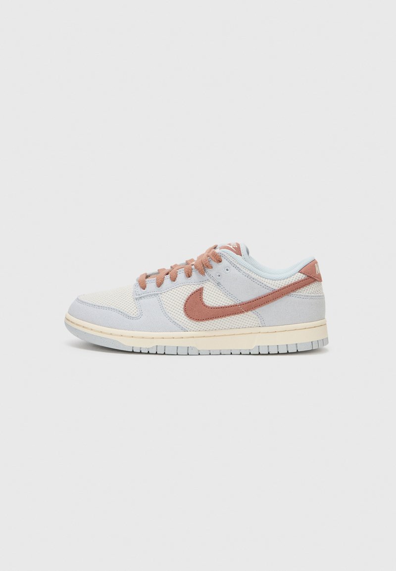 Šviesiai mėlyni Nike sportbačiai, pagaminti iš tinklinės medžiagos ir tekstilės, su rudais swoosh logotipais, šviesiai rudais viduriniais padu ir oranžiniais raišteliais.