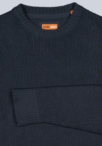 Dunkelmarineblauer gestrickter Rundhals-Pullover mit geripptem Kragen und Bündchen, zeigt einen gefalteten Ärmel und ein oranges Markenlabel im Kragen.