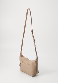 Bolso de hombro de cuero beige con un acabado texturizado, que presenta un bolsillo con cremallera en la parte frontal y una correa de hombro ajustable.
