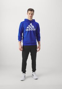 adidas Sportswear SPORTSWEAR HOODED TRACKSUIT SET - Tuta - semi lucid blue/black
