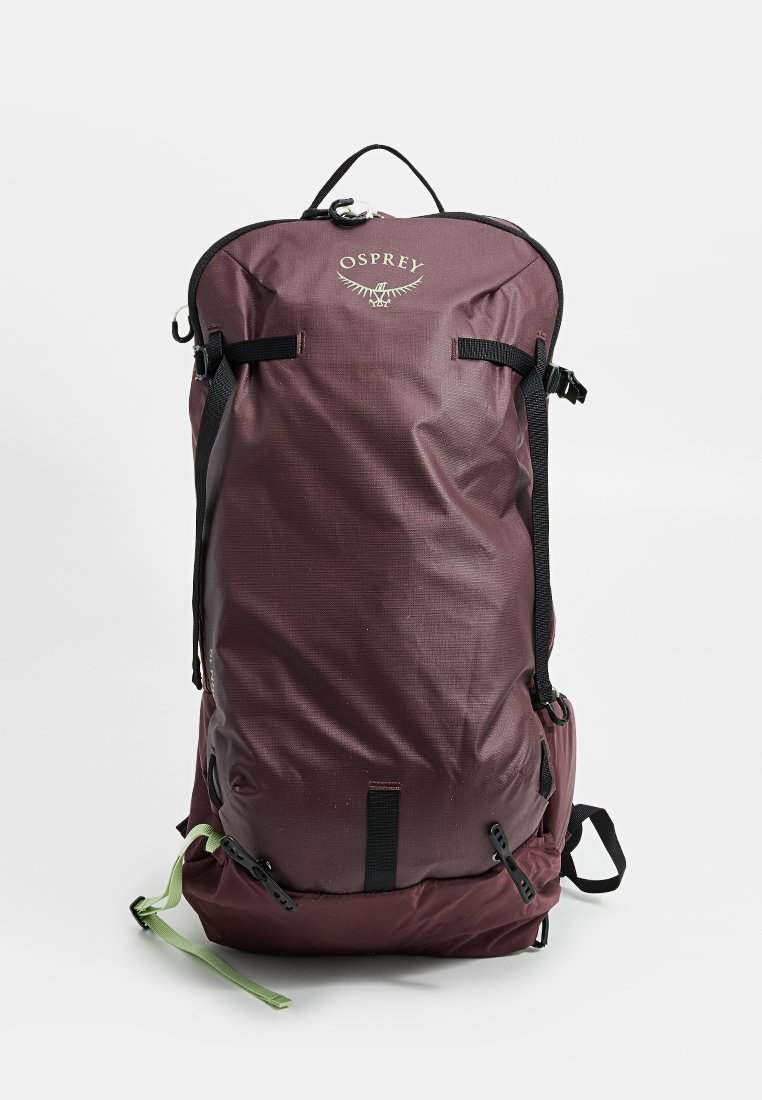 Mochila Osprey en color burdeos con correas negras, un asa en la parte superior y un acento verde. Fabricada en tejido texturizado, cuenta con hebillas ajustables y bolsillos laterales.