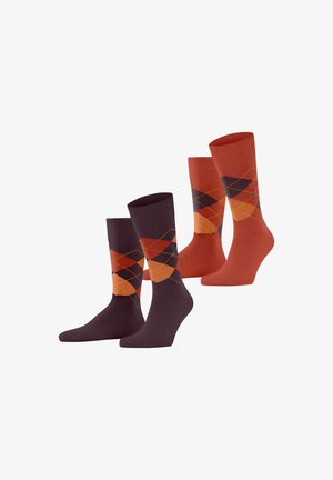 Zwei Paar Socken in dunklem Lila und Orange. Ein Paar zeigt ein Rautenmuster in Farbtönen von Orange, Rot und Gelb. Glatte Textur.