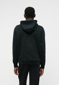 Sweatshirt preto com capuz, de textura suave, com punhos e bainha canelados e um corte descontraído, exibido de costas contra um fundo neutro.