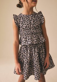 Šaty s leopardím vzorem z lehké látky, s volánkovými rukávy, vícevrstvým designem a nařaseným pasem. Zemité tóny s černými skvrnami.