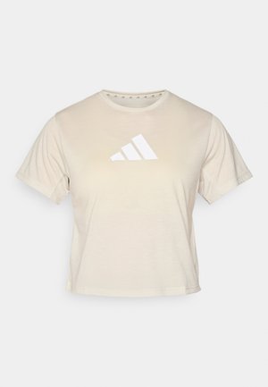 T-shirt beige a maniche corte realizzato in tessuto morbido, con un grande logo Adidas bianco a tre strisce sul petto. Collo classico a girocollo.