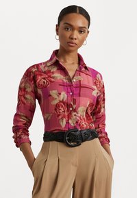 Floral-patterned shirt in pink and beige shades, featuring a collar, long sleeves, and button-up design. Paired with a black braided belt.