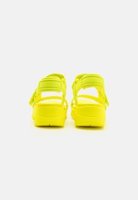 Infradito giallo neon con più cinturini regolabili e suole imbottite. Presentano una punta arrotondata e supporto per il tallone per un maggiore comfort.