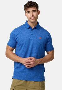 Polo bleu avec un tissu texturé, manches courtes et un col traditionnel. Présente un petit logo orange sur la poitrine.