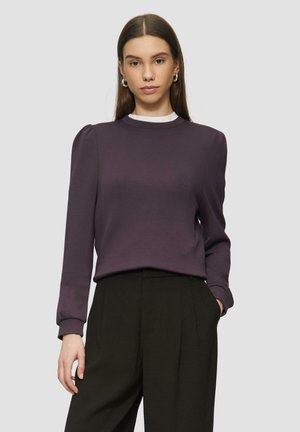 Haut violet à manches longues avec un col rond, des épaules bouffantes et des poignets côtelés. Assorti à un pantalon noir taille haute.