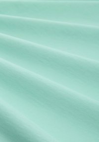 Mjuk, slät tyg i mintgrön färg, med subtila veck och en enkel textur utan synliga mönster eller detaljer.