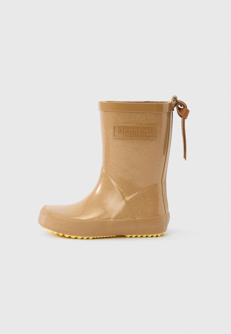 Gyermekméretű bézs színű csillogó esőcsizma texturált talppal, márkajelzéssel az oldalon és bőr lehúzó füllel a hátsó részen.