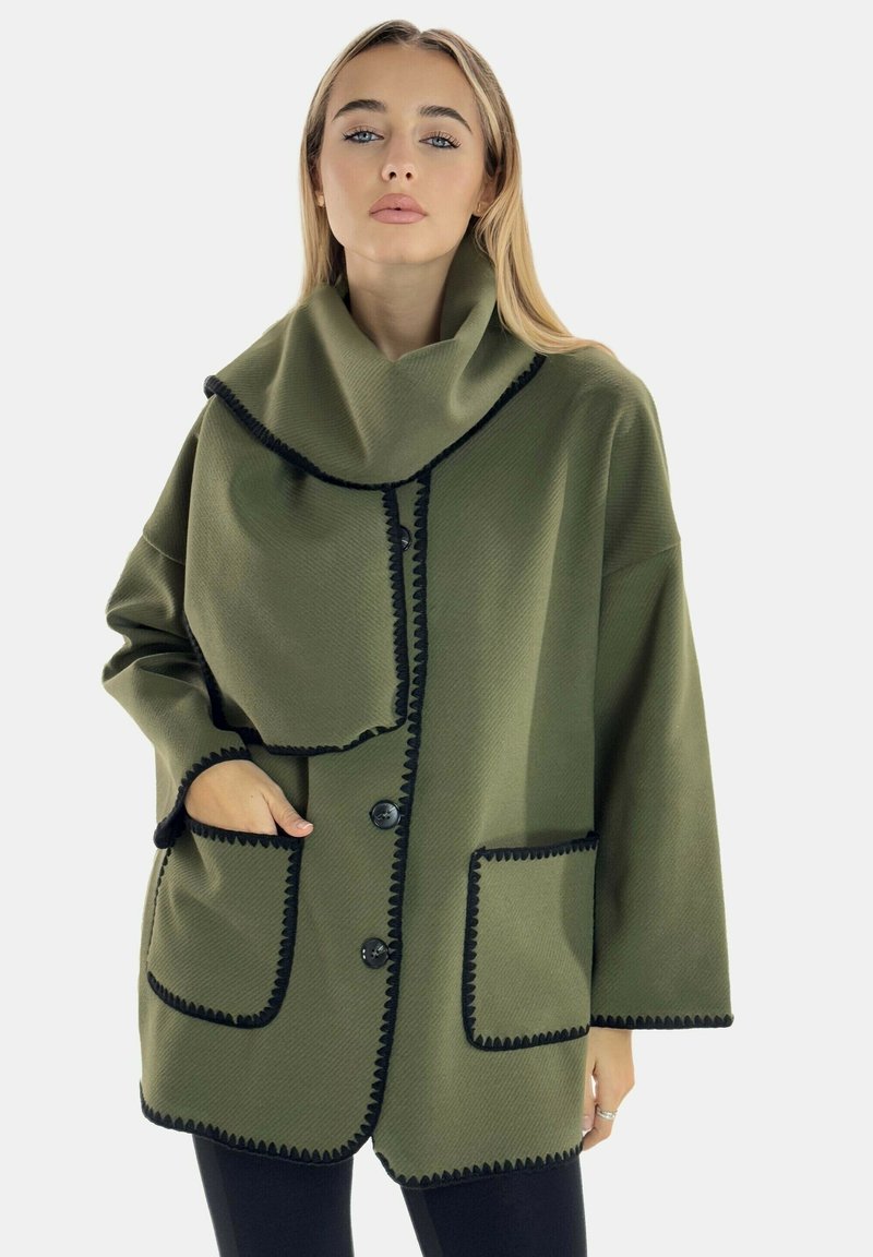Chaqueta verde oliva con un amplio cuello, ribete negro, dos bolsillos delanteros y cierre de botón. Tela de textura suave con un diseño de corte holgado.