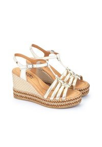 Sandales compensées en cuir doré avec un talon en jute tissé, bout ouvert et plusieurs brides à l'avant. Bride de cheville réglable avec détail de boucle.