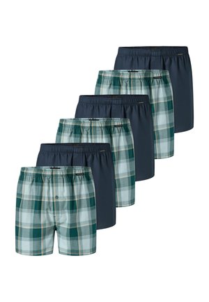 Zes herenboxershorts, afwisselend effen donkerblauw en groen geruit patroon, netjes gestapeld in een verspringende opstelling.