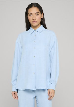 Hellblaues Hemd aus weichem Stoff mit klassischem Kragen, langen Ärmeln und lockerem Schnitt mit geradem Saum.