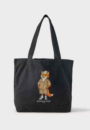 Zwarte draagtas met twee handvatten, met een illustratie van een vos in een hoed en korte broek en de tekst "Maison Kitsuné Paris" eronder.