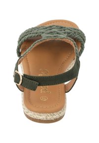 Sandalo con cinturino superiore intrecciato verde e suola piatta in espadrille. Presenta una soletta imbottita marrone e una fibbia dorata su un cinturino verde alla caviglia.