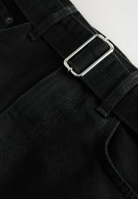 Schwarze Jeanshose mit strukturierter Oberfläche, ausgestattet mit einer silbernen Metallschnalle, Gürtelschlaufen und kontrastierenden Nähten entlang der Nähte.