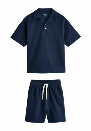 Polo bleu marine à manches courtes avec deux boutons et short assorti à taille élastique avec cordon blanc.