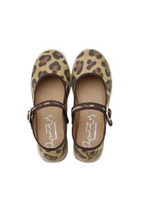 Zapatos Mary Jane con estampado de leopardo sobre un fondo beige, detalles en marrón, tela suave y una correa con hebilla. Diseño plano con punta redondeada.