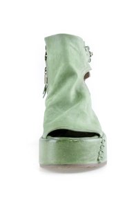 Chaussure plateforme en daim vert avec bout ouvert, détail éclair et boucle sur le côté, et semelle épaisse, vue de face.