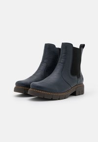 Bottines en cuir bleu marine avec des panneaux latéraux élastiques, un col matelassé et une semelle extérieure en caoutchouc épaisse avec un motif de crampons texturé.