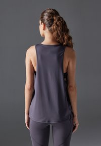 Dark grey athletic tank top with a relaxed fit, featuring a round neckline and cut-out sides, made of lightweight, breathable material.