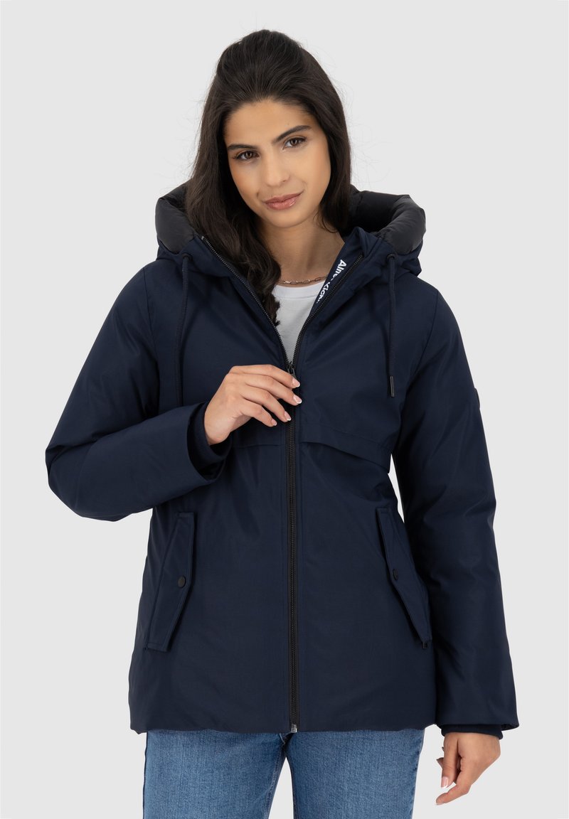 Giacca isolante blu navy con cappuccio, dotata di chiusura con zip, due tasche frontali e polsini elastici. Realizzata in un tessuto morbido e resistente alle intemperie.