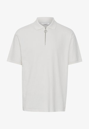 Valge polo särk, mis on valmistatud pehmest materjalist, lühikeste varrukatega, varustatud tõmbluku kaelaosaga koos hõbedaste detailidega ja laheda lõike disainiga.