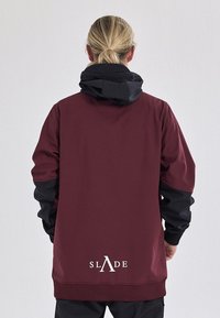 Bordeaux sweatshirt met een zwarte capuchon, voorzien van een logo "SLADE" in het wit op de onderrug en textuuraccenten op de mouwen.