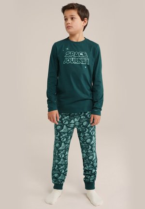 Groene pyjama top met lange mouwen met daarop de opdruk "SPACE JOURNEY", gecombineerd met groene broek met patronen van ruimte-thema's en boorden.