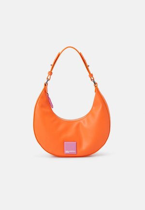Bolso naranja en forma de media luna con correa ajustable, tirador de cremallera rosa y parche con logo rosa en el frente sobre fondo blanco.