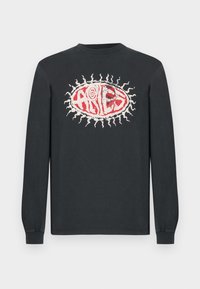 Tricou negru din bumbac cu mânecă lungă, având un grafic central roșu și alb cu inscripția "ARIES" înconjurată de motive radiante.