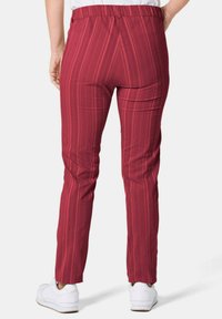 Rood gestreepte broek met een elastische tailleband, slim fit en een gladde stofstructuur, gecombineerd met witte sneakers.