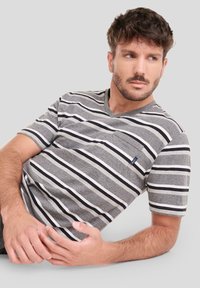 Camiseta de manga corta gris en cuello en V con rayas horizontales en blanco y negro, que incluye un bolsillo en el pecho y una pequeña etiqueta de la marca.