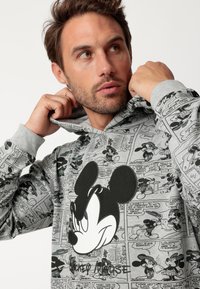 Sudadera gris con un gran gráfico de Mickey Mouse, rodeado de patrones de cómic que representan varias escenas y diálogos.