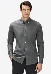 Långärmad skjorta i mörkgrått tyg, med klassisk krage, framknappar och figurnära design. Texturerad yta med subtila mönster.