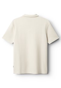 Polo tričko s krátkym rukávom v svetlo béžovej farbe, s textúrovaným vzorom, klasickým golierom a rovný lem so malou značkovou štítkom na boku.