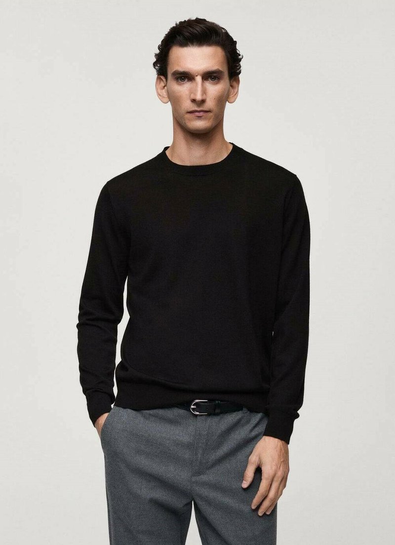 Maglione lavorato a maglia nero con scollo rotondo e maniche lunghe, abbinato a pantaloni grigi. Tessuto piatto, design semplice, senza motivi o accenti.