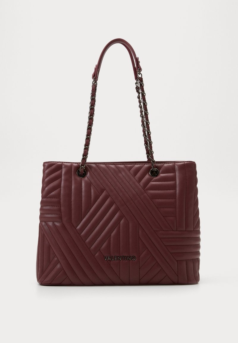 Sac en cuir matelassé bordeaux avec une bandoulière en chaîne, présentant un motif géométrique, un détail de logo et une forme structurée.