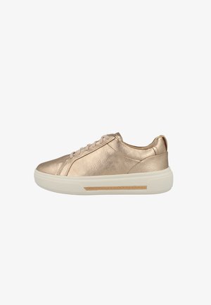 Futuristiset rose gold -tennarit, joissa on teksturoitu pinta, valkoinen kumipohja ja vaaleanpunaiset nauhat. Huomionarvoinen vaaleanruskea yksityiskohta sivulla.