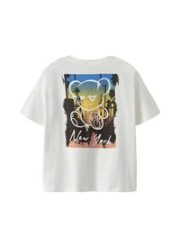 T-shirt blanc à manches courtes avec un coucher de soleil coloré, des palmiers, un contour d'ours blanc dégoulinant et le texte "New York" au dos.