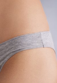 Szary bawełniany thong o gładkiej fakturze i wąskim elastycznym pasku w talii, prezentujący minimalistyczny design i bezszwową konstrukcję.